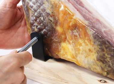 生ハムを開封し、写真のようにホルダー金具の間に安定する形で置いたら、ヒートンをホルダー金具の外側から差し込む。